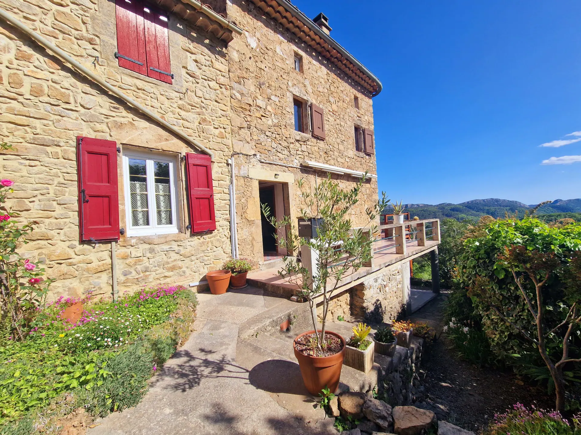 Façade en pierre de la Bastide et volets rouges